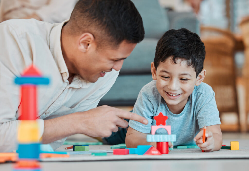 Adult and child building a colorful structure with blocks at home, representing the nurturing role of guardianship and how it can intersect with parental rights