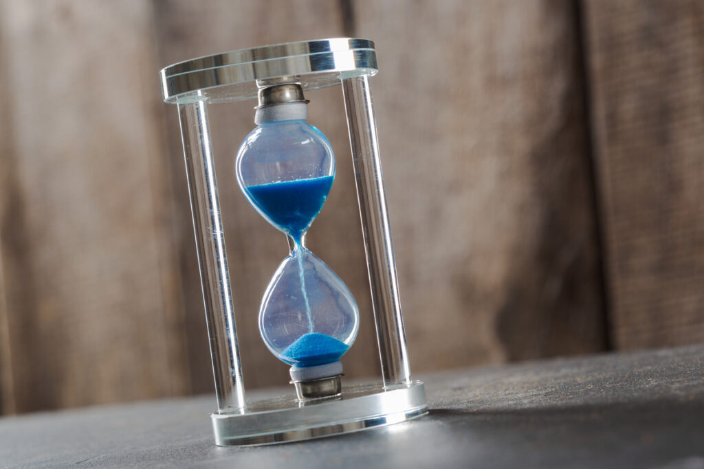Hourglass with blue sand, illustrating what is the statute of limitation on medical malpractice. This image emphasizes the time-sensitive nature of legal cases in medical malpractice