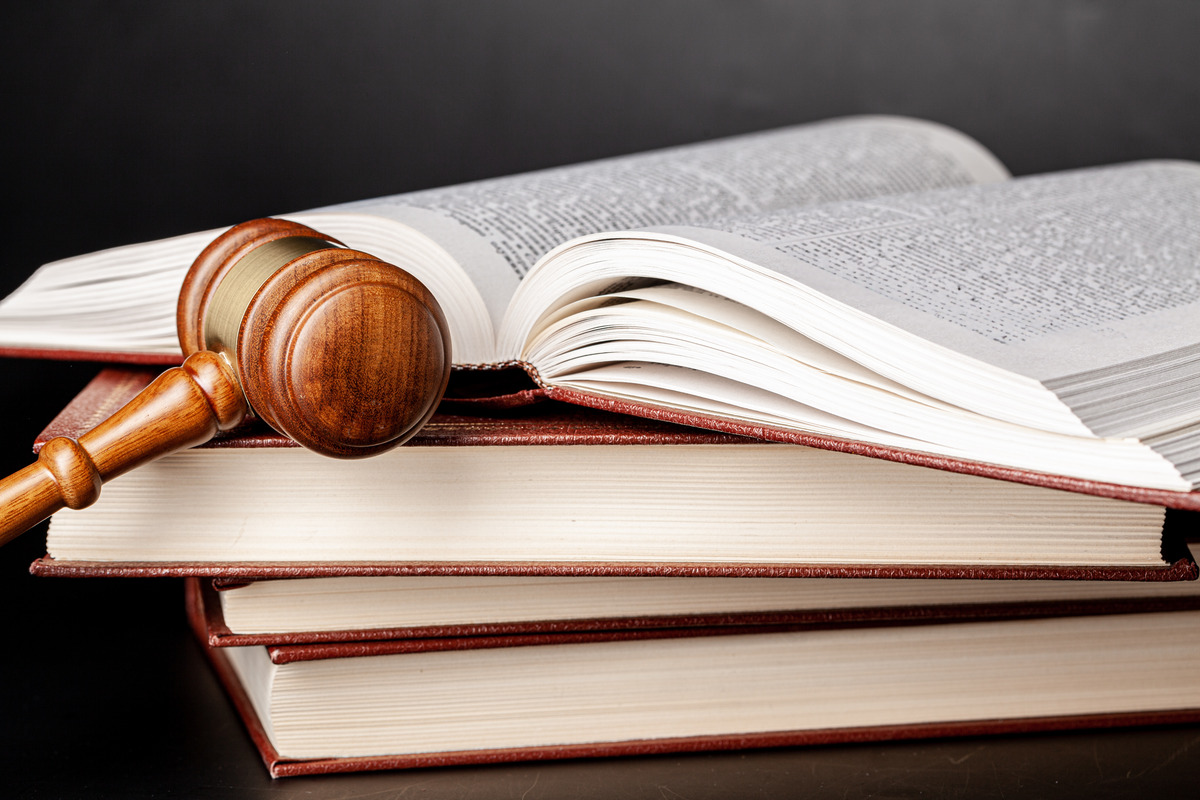 Gavel resting on a stack of law books, illustrating what is the difference between assault and battery. This image symbolizes the legal system and the importance of understanding distinctions in legal terms