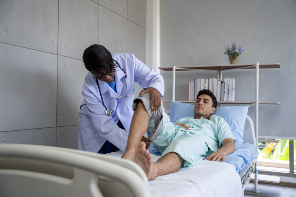 A male patient is being assessed by a doctor for a leg injury, illustrating the attentive nature of medical evaluations