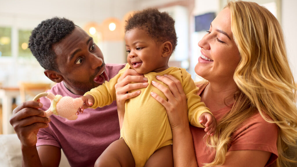 A man and woman gaze lovingly at a baby they are holding, symbolizing the emotional weight of parental rights termination