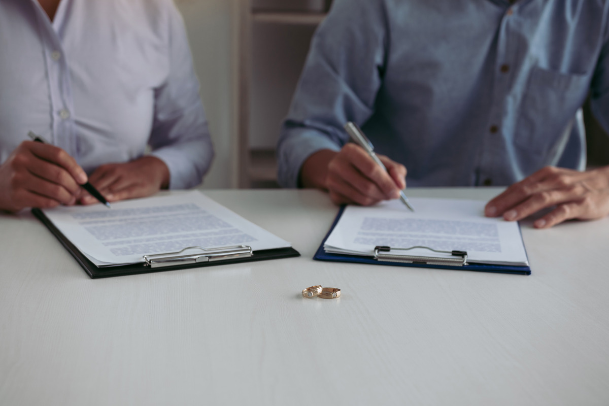 Couple signing a divorce documents, symbolizing a collaborative approach to divorce proceedings