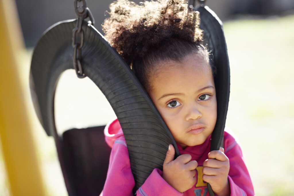 A young girl sits on a swing, symbolizing innocence amidst the complexities of parental rights termination.