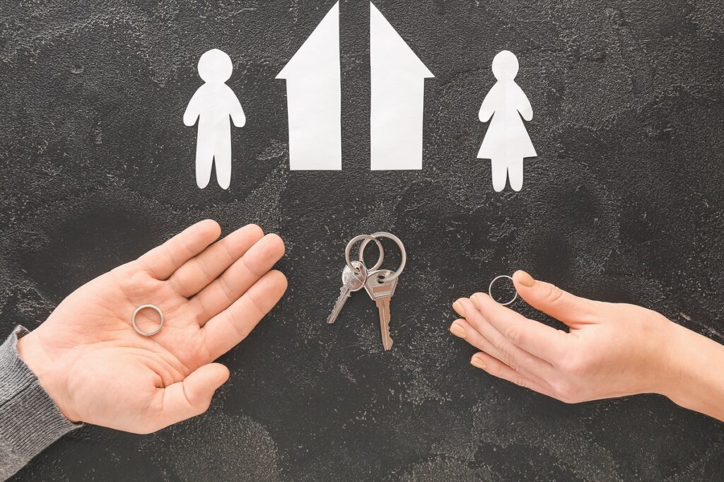 Hands holding keys alongside a sign reading "family," symbolizing property division in legal contexts