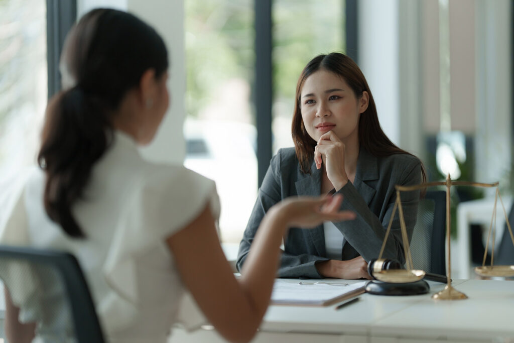 A property division lawyer in a business suit engages in conversation with a colleague