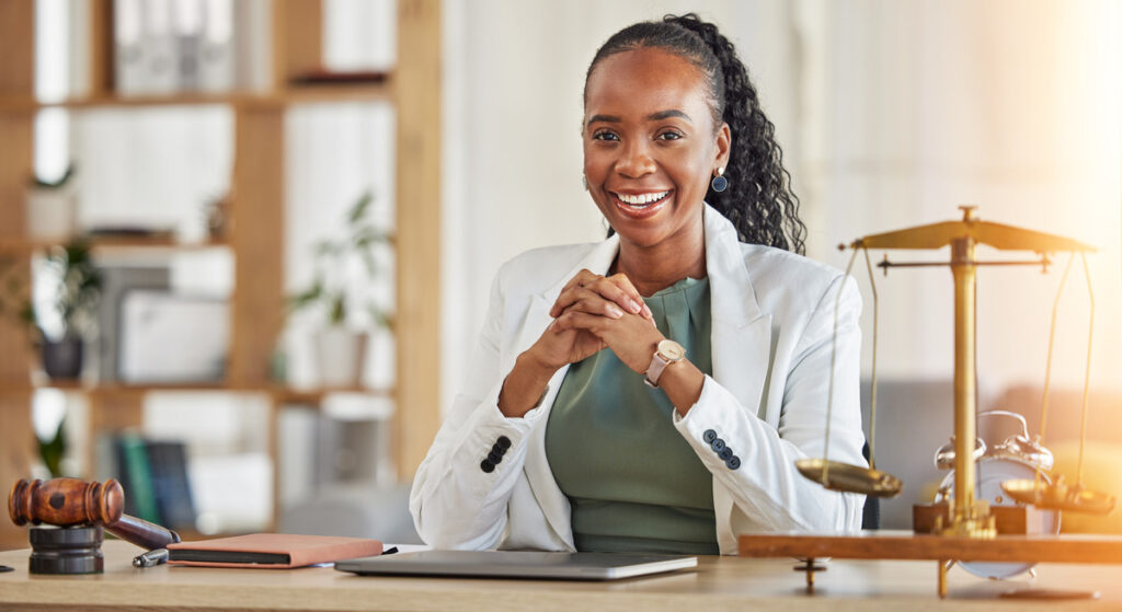 A family law lawyer in Houston, dressed in a business suit, sits at a desk with a laptop and a scale of justice