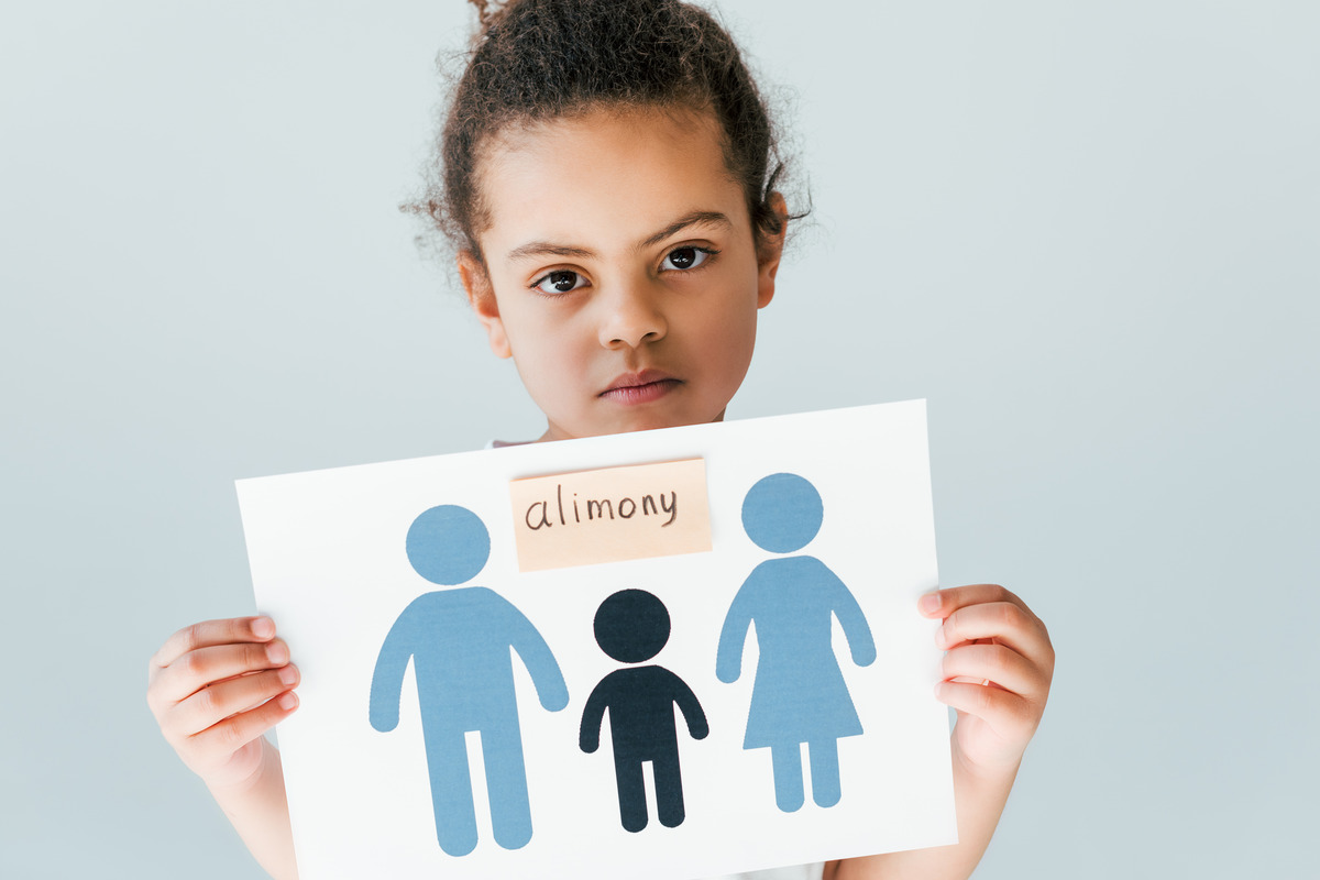 A sad kid holding a drawing of family in paper