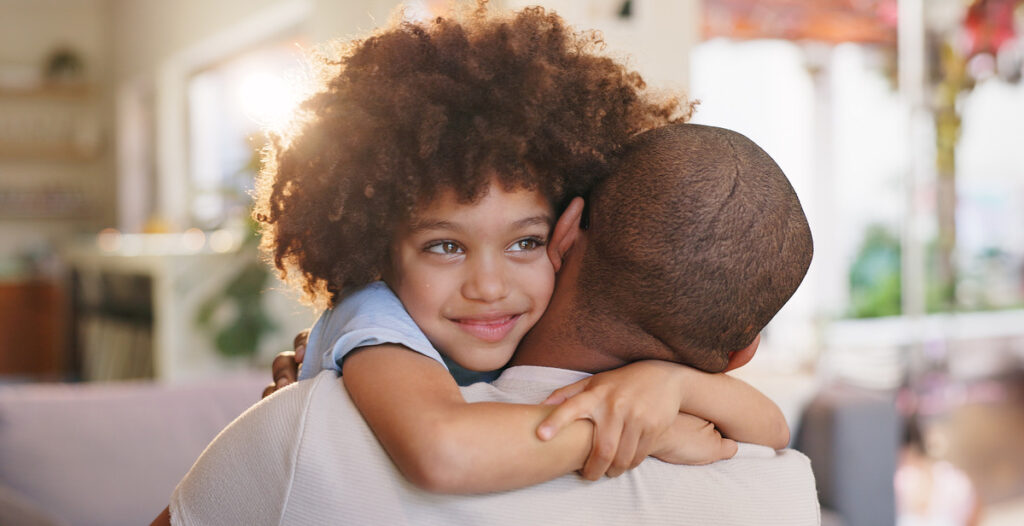 A happy child hugging their father
