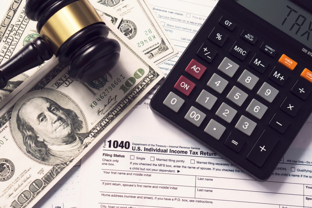 A gavel with a calculator and a US Individual Income Tax Return document