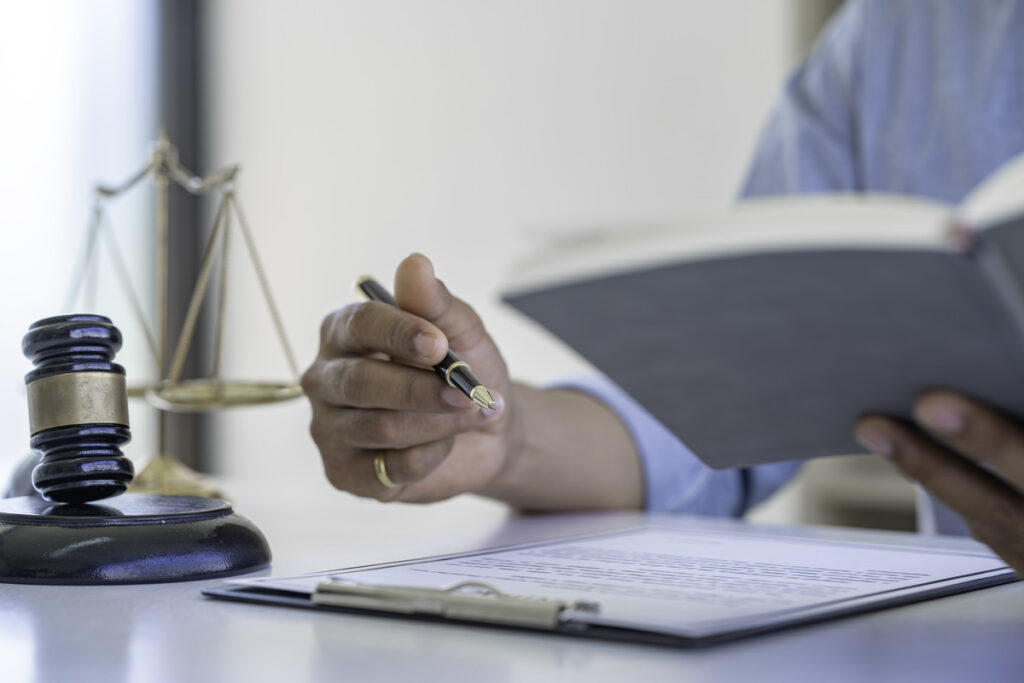 A lawyer writing notes with a gavel and scales on justice on the side