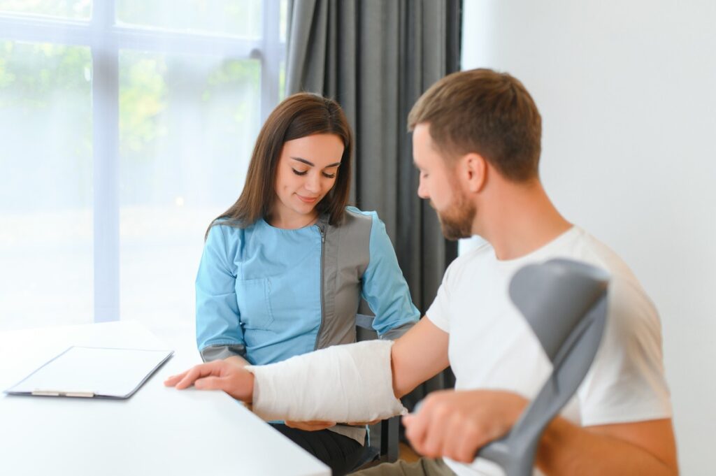 a doctor helping a patient wrap up the cast