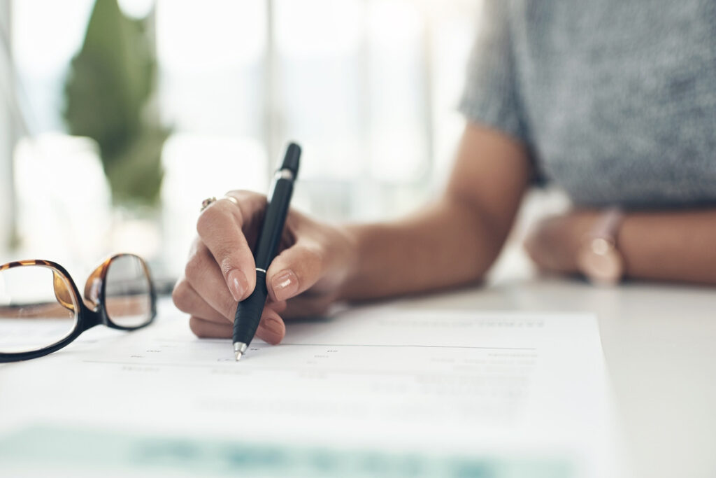 close up shot of a pen signing a document