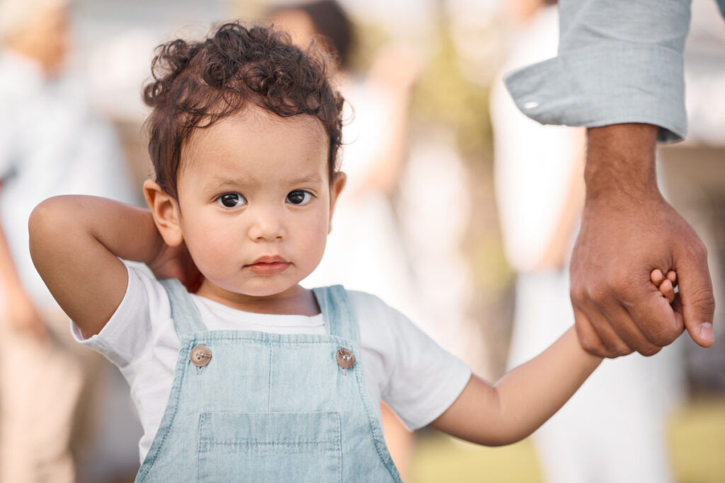 Portrait of a child holding hands with a parent