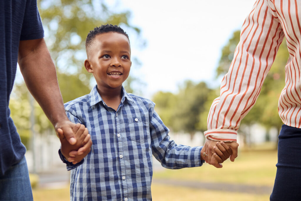 a child holding hands with his parents