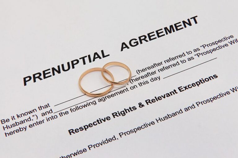Wedding ring placed on top of a prenuptial agreement document, symbolizing the intersection of love and legal planning before marriage.